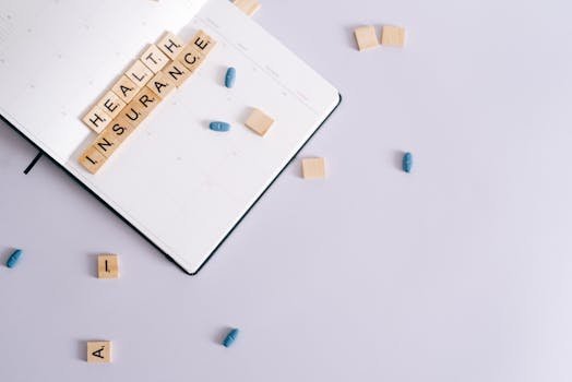 Flat lay of health insurance concept with planner and pills.